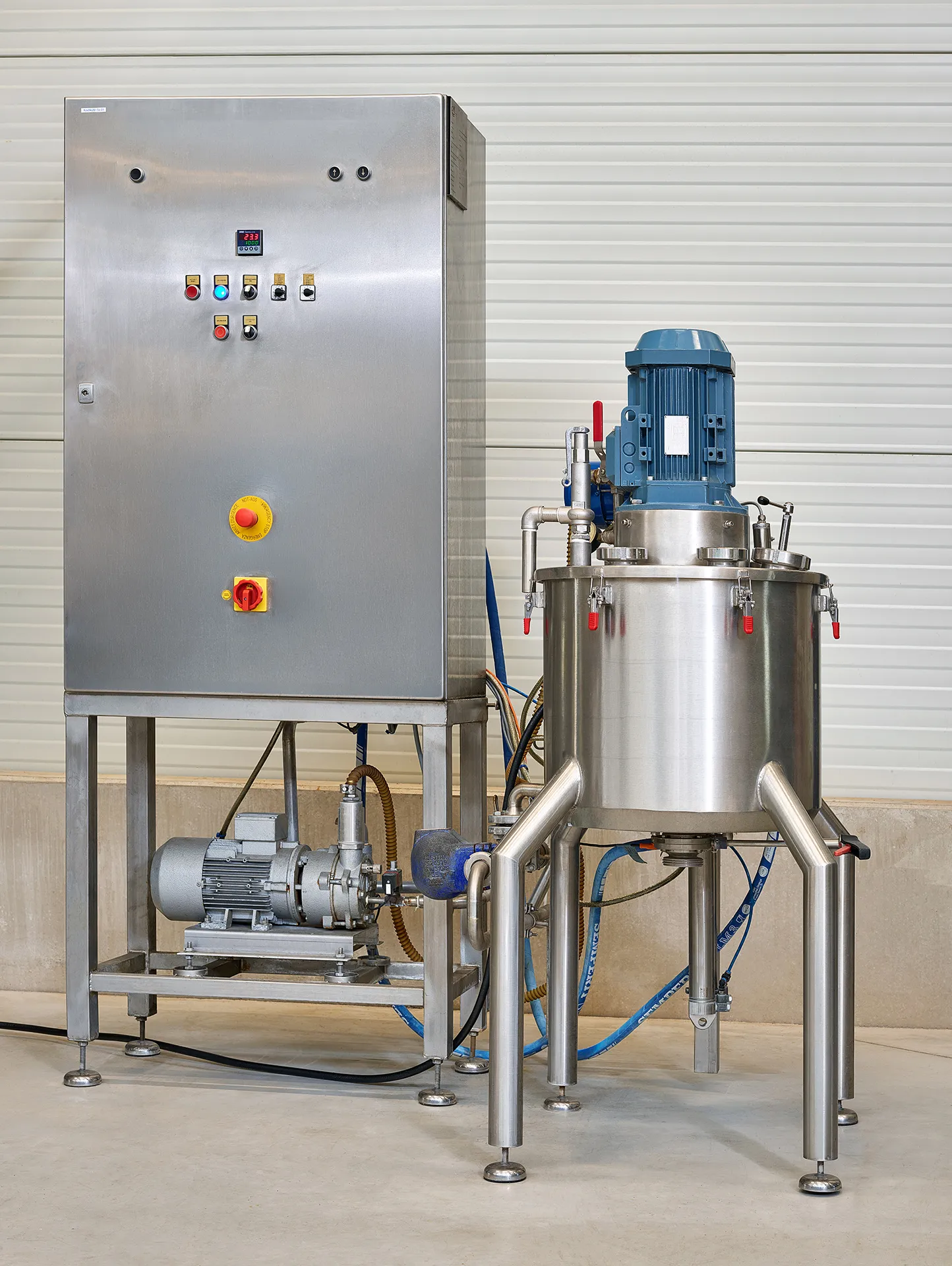 Compact stainless-steel mixing installation with a blue electric motor and a control cabinet