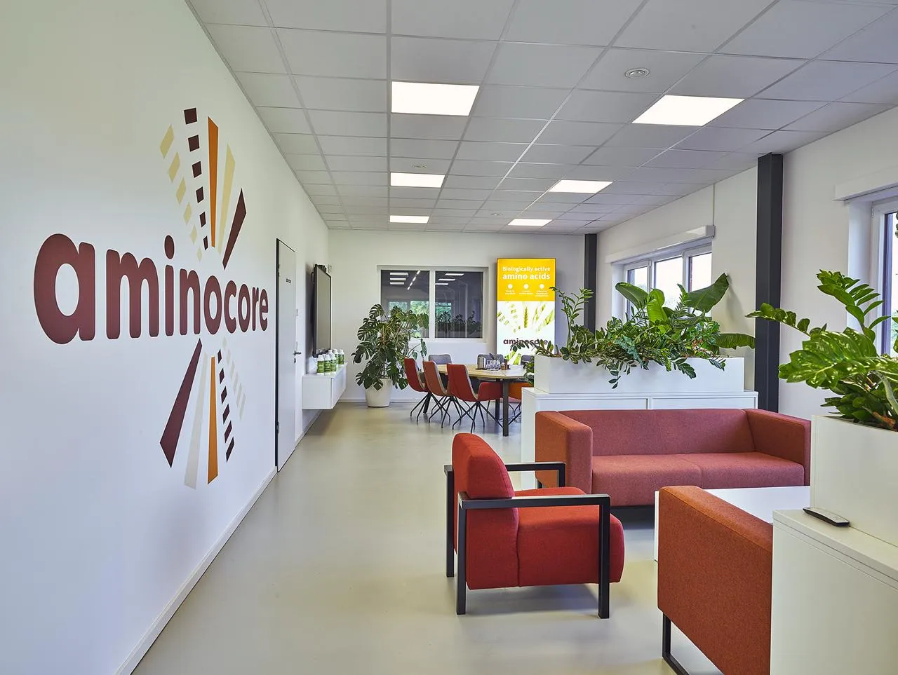 Aminocore office lounge with the Aminocore logo on the wall