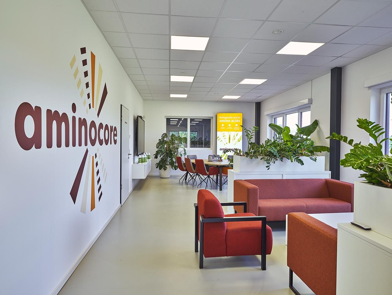 Lounge do escritório da Aminocore com o logotipo da Aminocore na parede